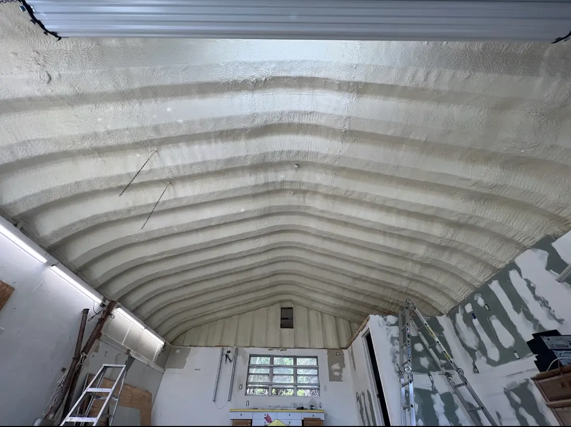 Spray polyurethane foam applied to the underside of a metal roof deck in Sussex